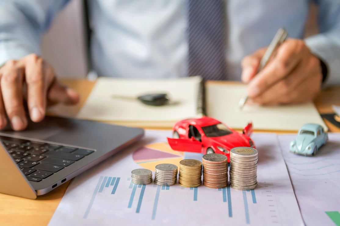 Auto financing calculator with coins and toy cars showing loan planning and budgeting for Georgia families